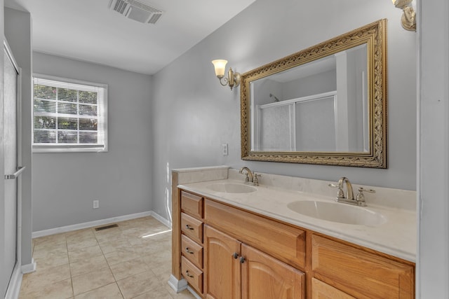 bathroom with walk in shower, vanity, and tile patterned flooring