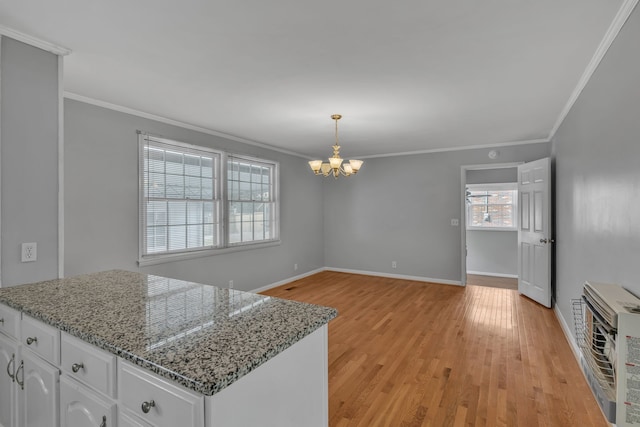 kitchen featuring light wood-type flooring, ornamental molding, and white cabinetry