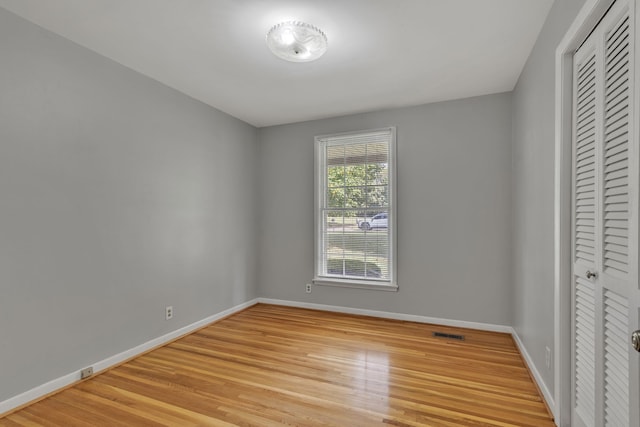 unfurnished bedroom featuring light hardwood / wood-style flooring and a closet