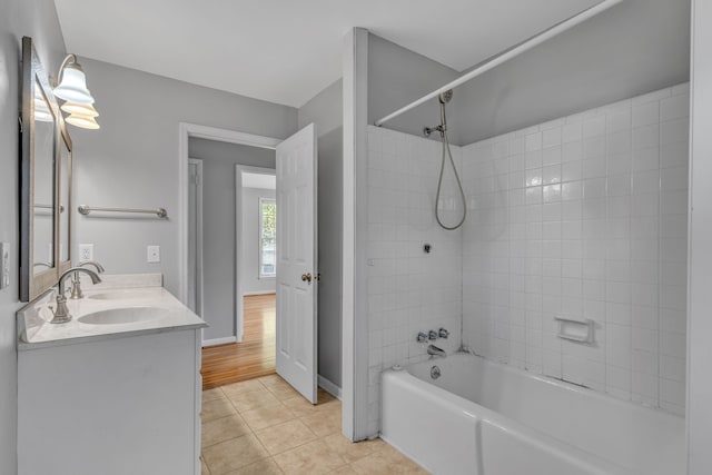 bathroom with hardwood / wood-style floors, tiled shower / bath combo, and vanity