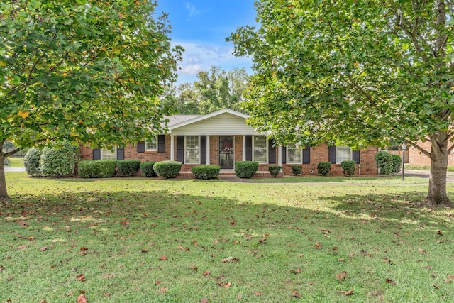 view of property hidden behind natural elements featuring a front lawn