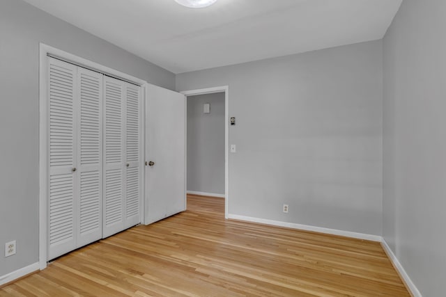 unfurnished bedroom with light hardwood / wood-style flooring and a closet