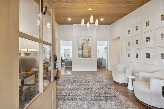 living room featuring wood ceiling, a chandelier, wood walls, and dark wood-type flooring