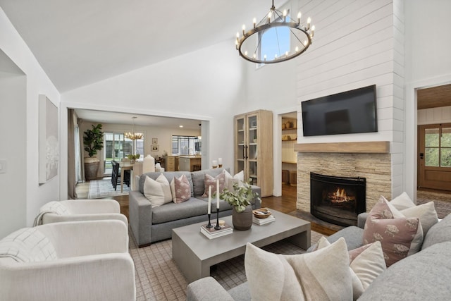 living room featuring a notable chandelier, a healthy amount of sunlight, and a fireplace