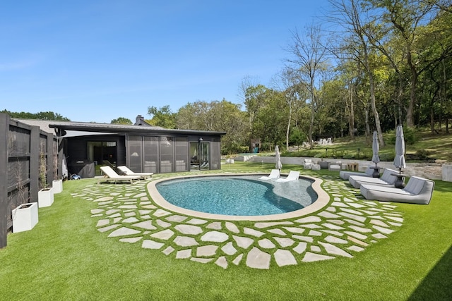 view of pool with a lawn, a patio, and a sunroom