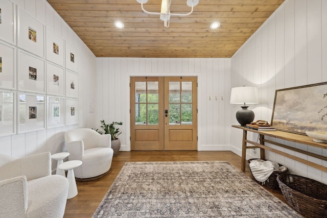 foyer featuring wooden ceiling, wooden walls, hardwood / wood-style floors, and french doors