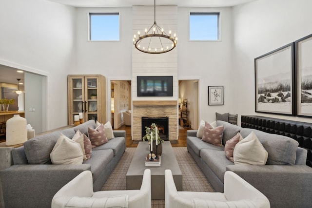 living room with hardwood / wood-style flooring, plenty of natural light, a chandelier, and high vaulted ceiling