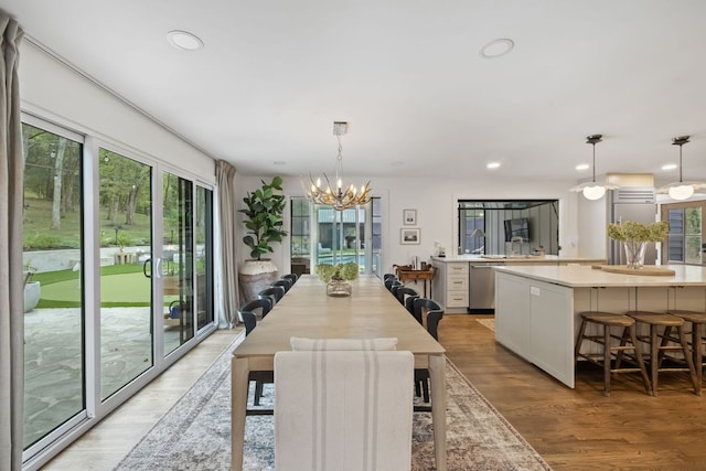 dining area with light hardwood / wood-style floors, a chandelier, and a wealth of natural light