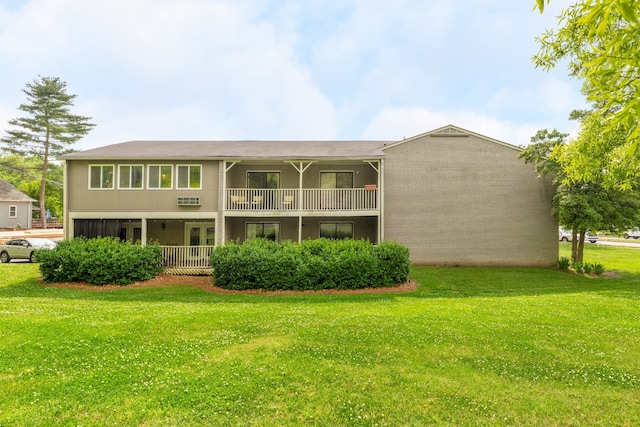 back of house with a balcony and a yard