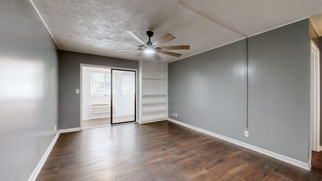 unfurnished bedroom with a wall mounted AC, ceiling fan, dark hardwood / wood-style floors, and a textured ceiling