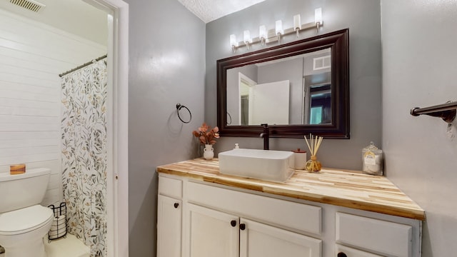 bathroom featuring curtained shower, vanity, and toilet