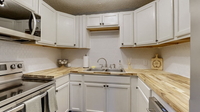 kitchen featuring butcher block counters, stainless steel appliances, and white cabinets