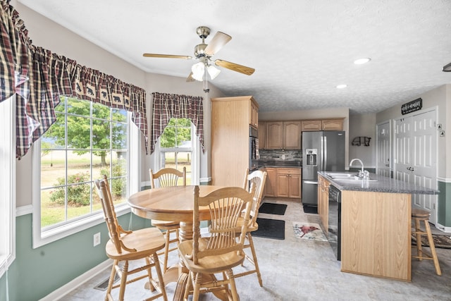 dining space featuring ceiling fan, a textured ceiling, and sink