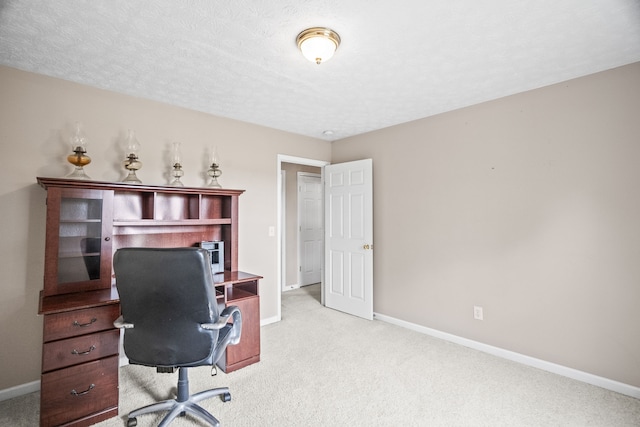 carpeted office space with a textured ceiling