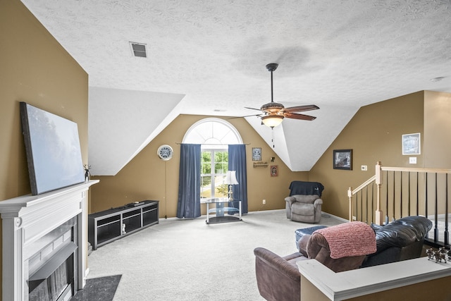 carpeted living room with ceiling fan, a textured ceiling, and vaulted ceiling