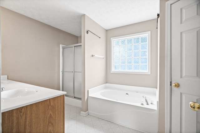 bathroom featuring plus walk in shower, a textured ceiling, and vanity