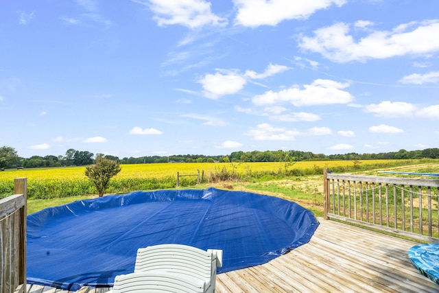 view of pool with a wooden deck and a rural view