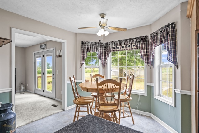 dining space with light carpet, a textured ceiling, and ceiling fan