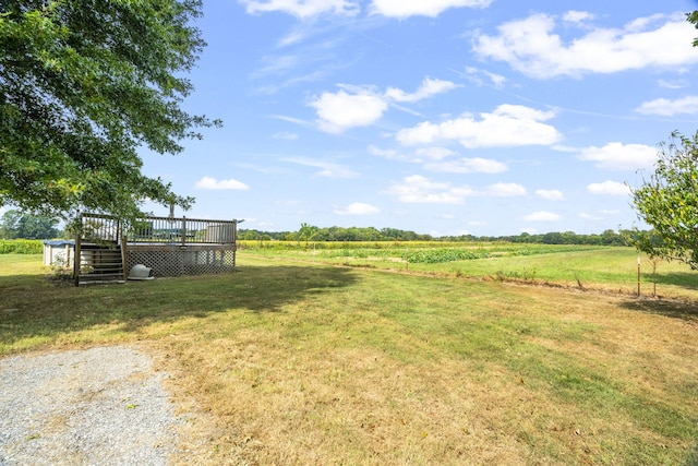 view of yard featuring a rural view and a wooden deck