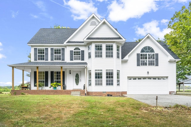 view of front of house featuring a front yard, a garage, and covered porch