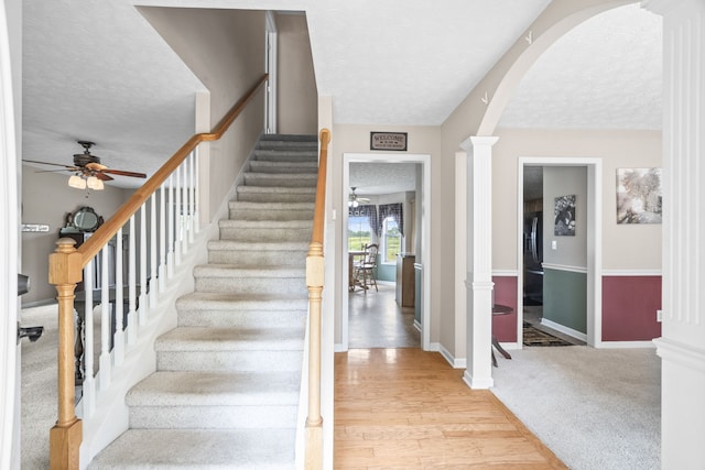 stairs featuring wood-type flooring, a textured ceiling, and ceiling fan