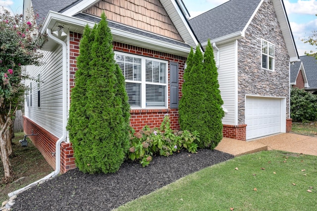 view of side of property featuring a garage and a yard