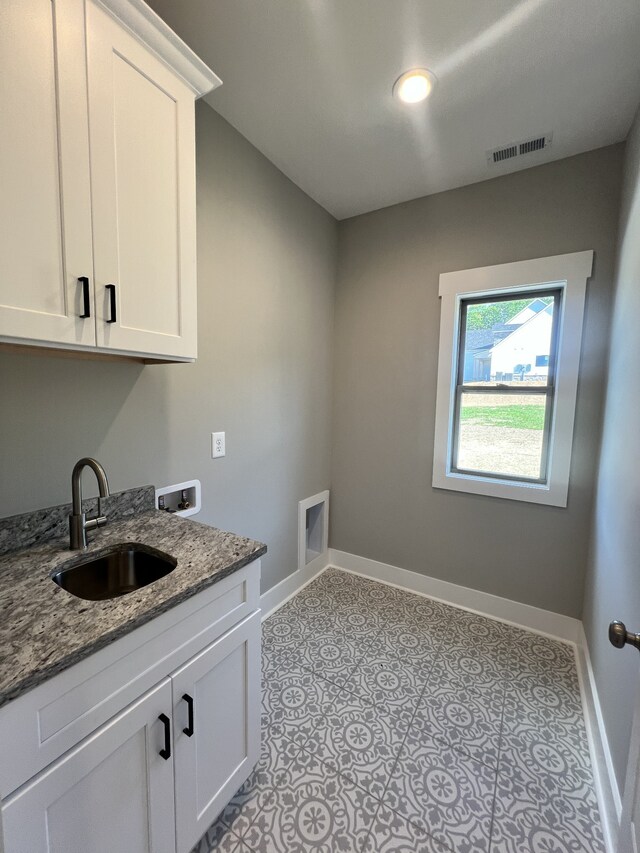 laundry room with cabinets, hookup for a washing machine, and sink