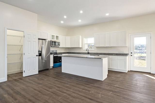 kitchen featuring a wealth of natural light, white cabinetry, a kitchen island, and stainless steel appliances