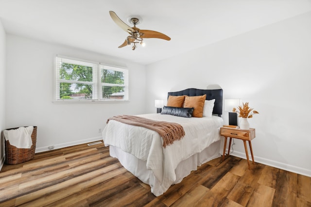 bedroom with dark hardwood / wood-style flooring and ceiling fan