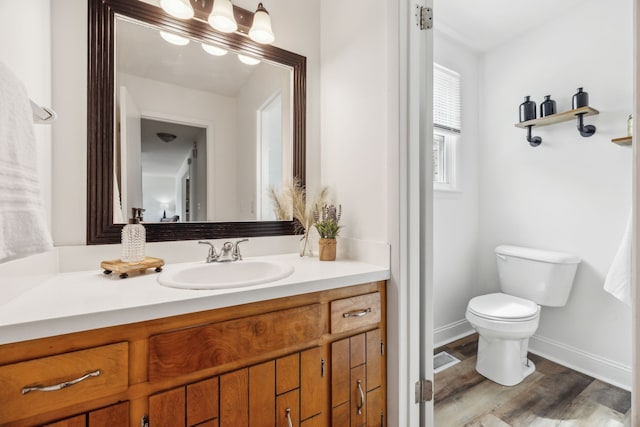 bathroom with vanity, toilet, and hardwood / wood-style flooring