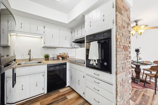 kitchen featuring white cabinets, black appliances, dark wood-type flooring, and sink