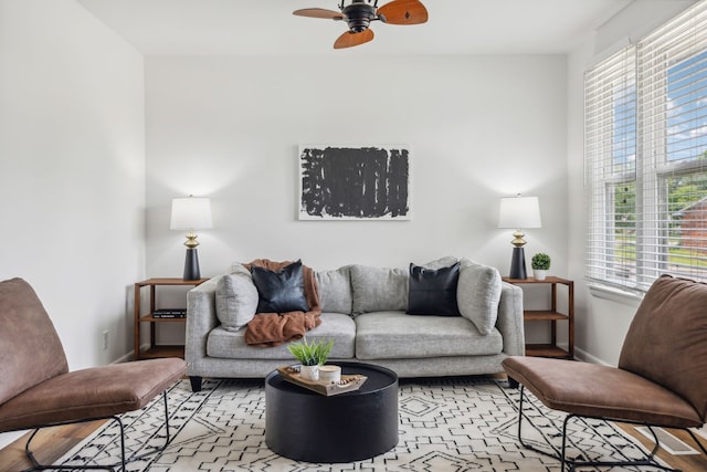 living room featuring light wood-type flooring, ceiling fan, and plenty of natural light