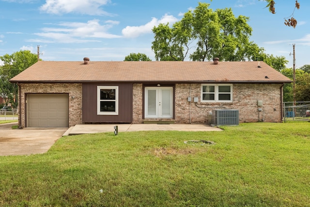 view of front of house featuring cooling unit, a front lawn, and a garage