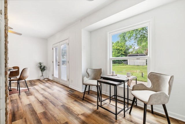 living area with french doors, hardwood / wood-style flooring, and plenty of natural light