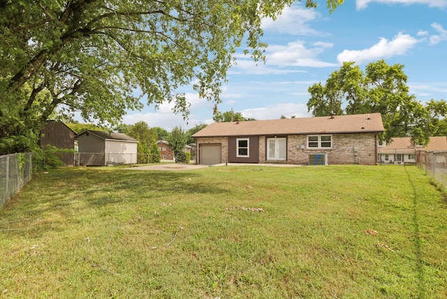 rear view of house with a lawn and a garage