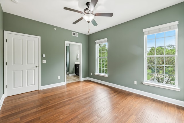 interior space featuring ceiling fan, hardwood / wood-style flooring, and connected bathroom