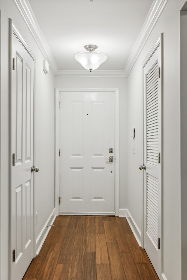 entryway with ornamental molding and dark hardwood / wood-style flooring