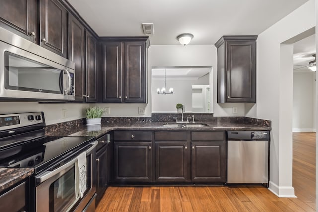 kitchen featuring light hardwood / wood-style flooring, stainless steel appliances, dark brown cabinetry, and sink