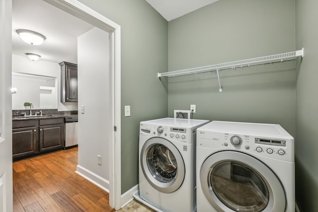 laundry room with hardwood / wood-style flooring, sink, and washer and dryer