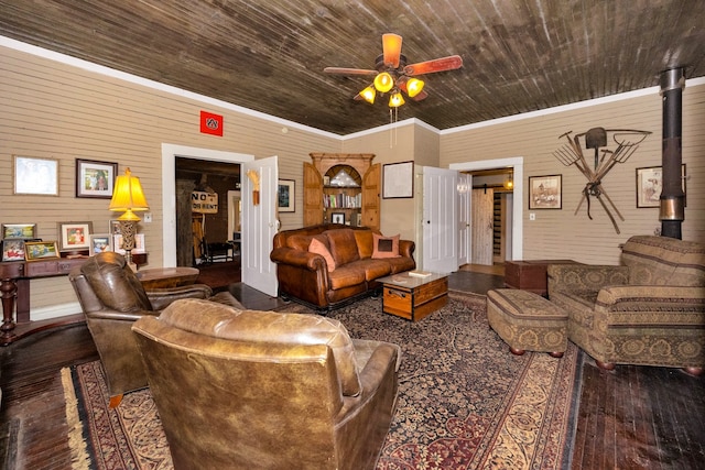 living room with wood ceiling, wood-type flooring, a wood stove, crown molding, and ceiling fan