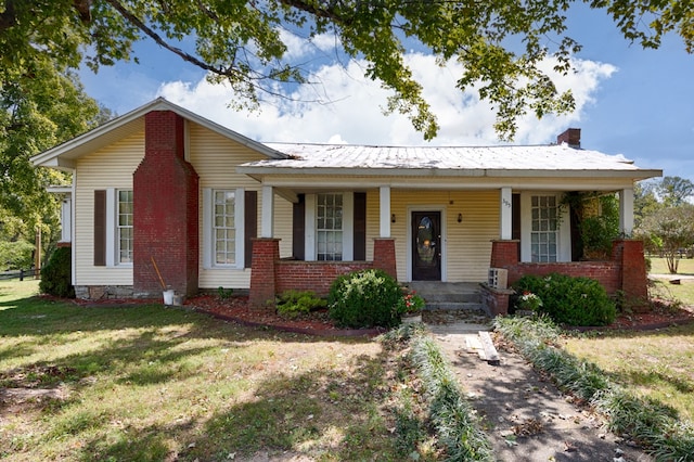 ranch-style house with a front yard and covered porch