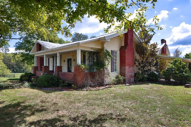 view of property exterior with a lawn and covered porch