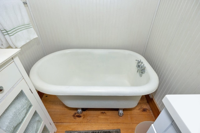 bathroom with hardwood / wood-style floors, vanity, and a bathing tub