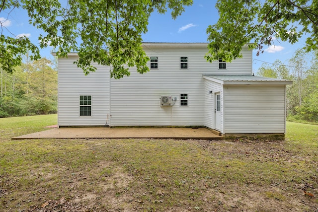 rear view of house with a lawn and a patio