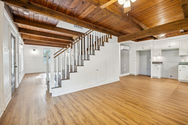 unfurnished living room with a wall unit AC, wood ceiling, beam ceiling, and light hardwood / wood-style flooring