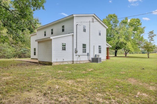 rear view of house featuring a yard and central AC unit