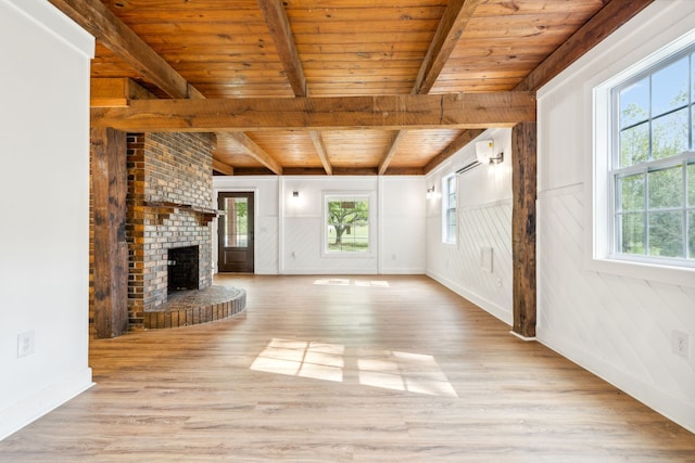 unfurnished living room with a brick fireplace, light hardwood / wood-style flooring, wood ceiling, and a healthy amount of sunlight