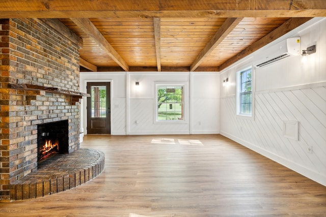 unfurnished living room featuring beamed ceiling, hardwood / wood-style flooring, wood ceiling, and a wall unit AC