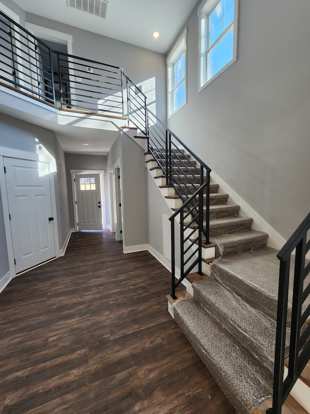 entrance foyer featuring a towering ceiling and dark hardwood / wood-style floors