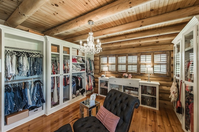 interior space with wood-type flooring, beam ceiling, and an inviting chandelier